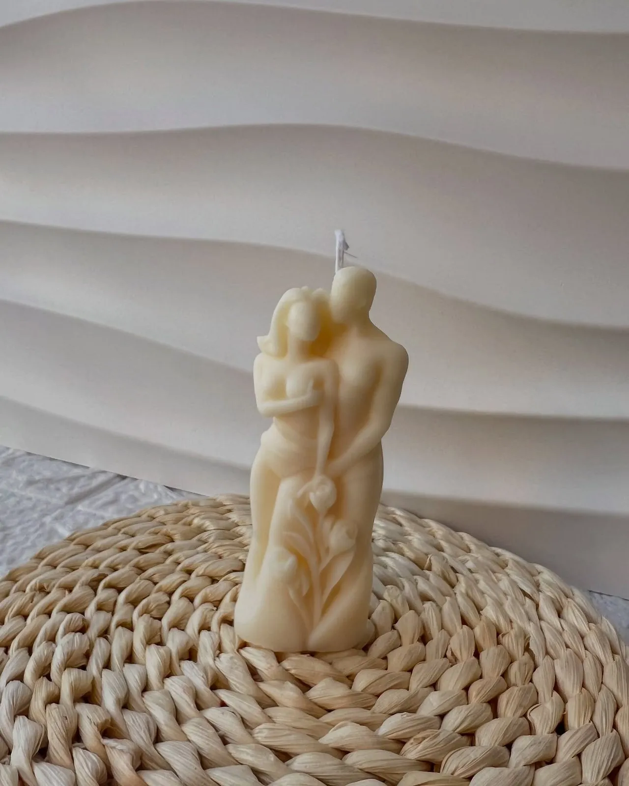 Qiri skulpturë me dy figura të përqafuara, mbi tapet kashte