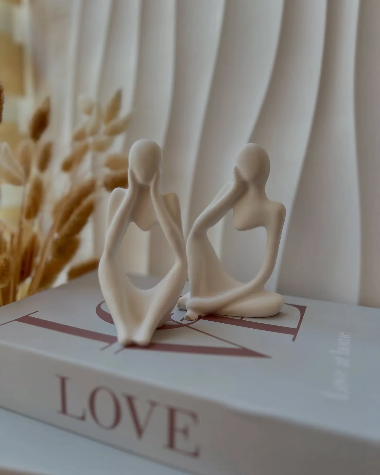 Two candle figures on a “Love” book