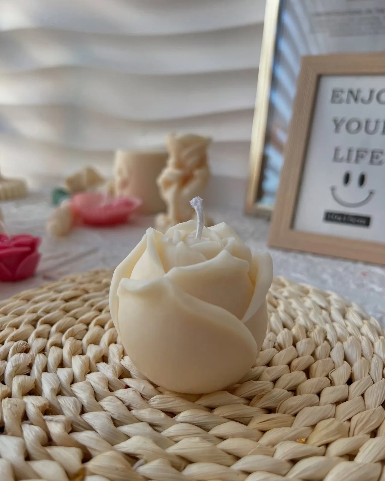 Rose-shaped candle on a straw mat